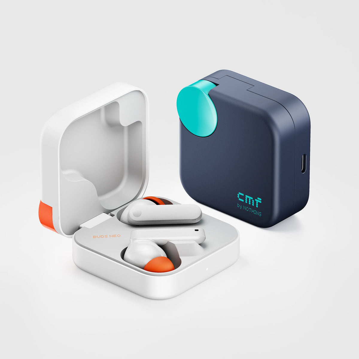 Buds Neo earbuds in the open White charging case beside the Dark Blue case with teal dial